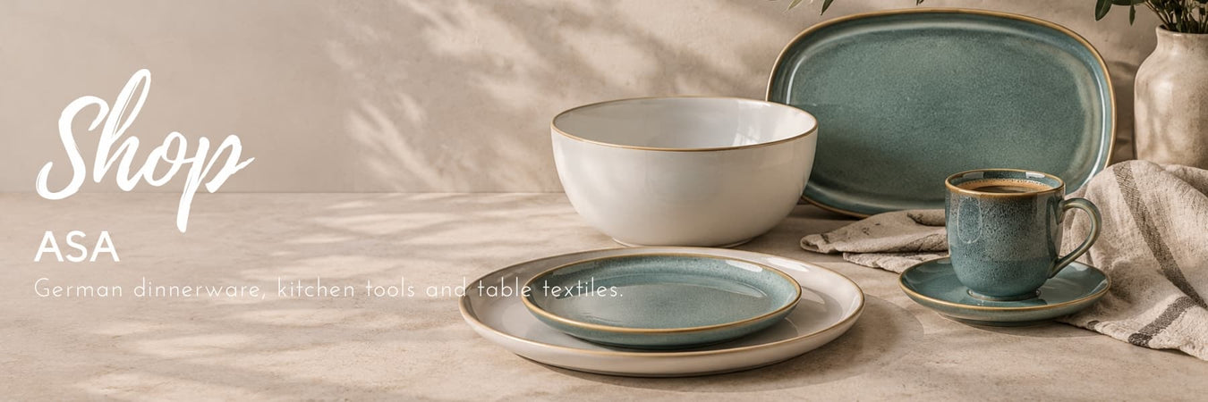 ASA ceramic dinnerware in soft blue and cream tones, styled with natural textiles on a neutral stone surface. Elegant German tableware for contemporary dining and entertaining. Lighting.co.za