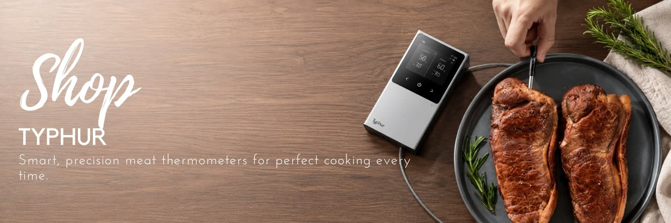 Typhur smart meat thermometer monitoring perfectly cooked steaks, styled on a wooden surface with fresh herbs. Precision cooking technology designed for accurate results every time.