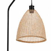 A natural woven rattan or wicker dome pendant shade hanging from a black metal ceiling canopy, with part of a black floor lamp stand visible on the left against a plain white background - Lighting.co.za