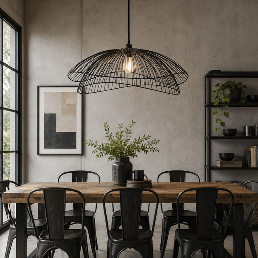 A black metal wire dome pendant light hangs over a rustic wooden dining table with black metal chairs in a modern, industrial-style dining room - Lighting.co.za