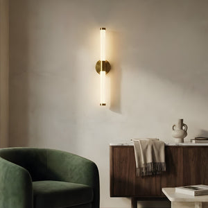 Modern interior with a green armchair, wooden side table, and wall sconce.