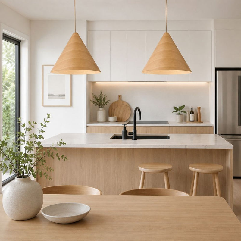 A modern kitchen interior with a light wood island, white cabinetry, a white marble countertop, black faucet, and two hanging oak veneer wooden pendant lights - Lighting.co.za