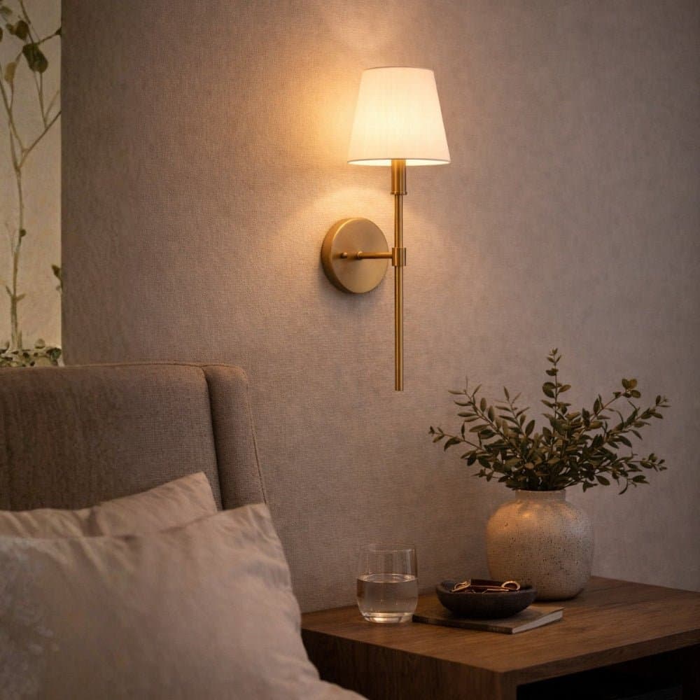 Gold and White Shade Wall Light on a neutral wall with a table and decorative items in a cozy room. - Lighting.co.za