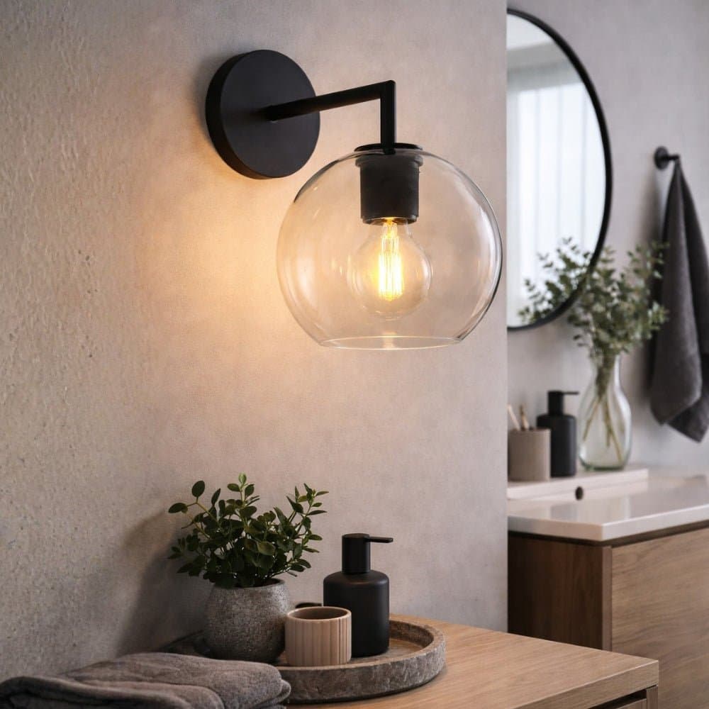 Modern wall sconce with a clear glass shade in a bathroom setting. - Lighting.co.za