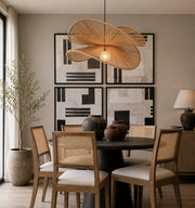 The sculptural rattan pendant now becomes the focal point of the dining room, complementing the cane chairs, dark pedestal table, earthy ceramics, and warm neutral palette while remaining illuminated - Lighting.co.za